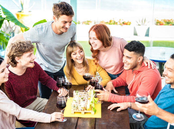 Trendy young people having fun together drinking wine at penthouse on private home garden - Happy friends enjoying time together at restaurant lounge - Dining life style concept on bright vivid filter